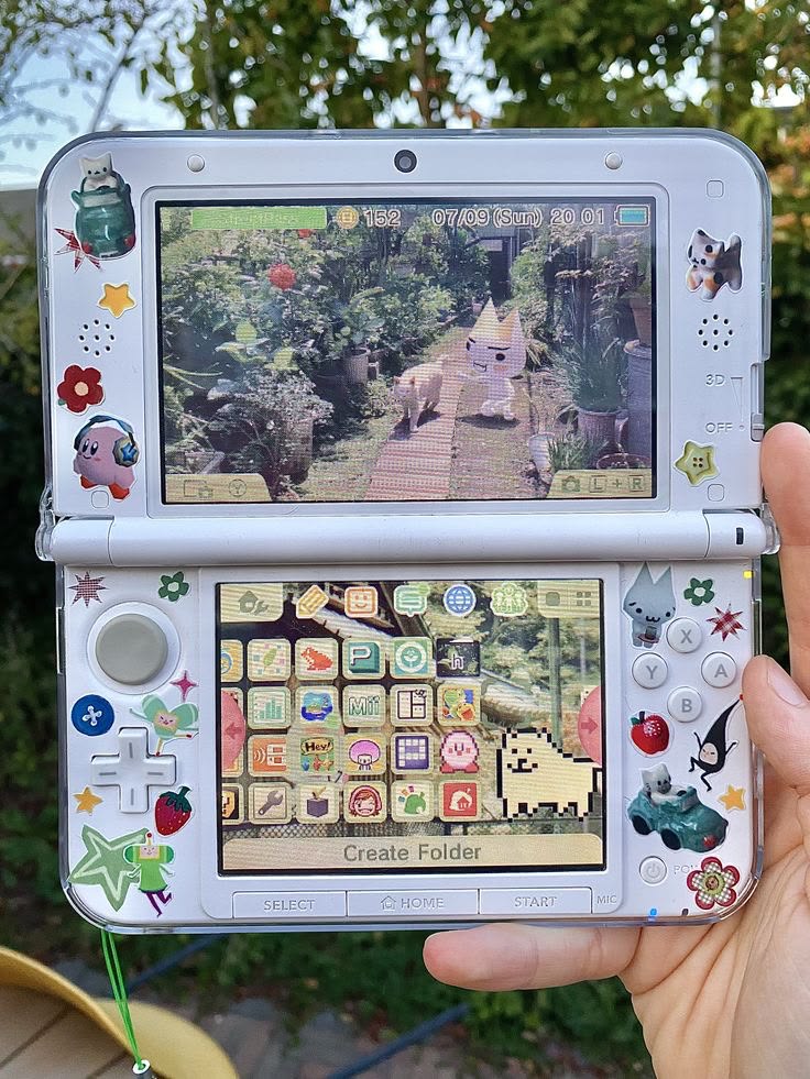 White Nintendo 3DS XL decorated with Toro Inoue and cute stickers, held outdoors showing game screens