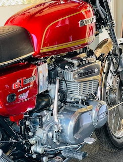 Suzuki GT380 motorcycle engine with red tank and chrome cylinders