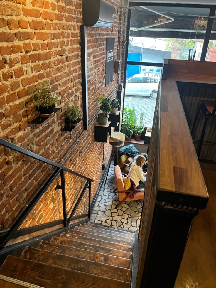 Aerial view of cafe staircase with brick walls and wooden counter