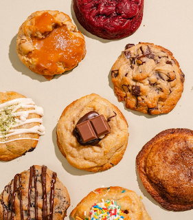 Eight assorted cookies including chocolate chip, snickerdoodle, and glazed varieties on a beige background