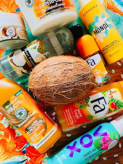 Flat lay of tropical coconut-themed beauty products with a whole coconut in the center