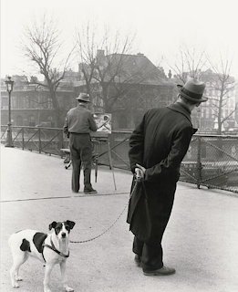Fox Terrier dog on leash with owner on Paris bridge, black and white vintage photograph