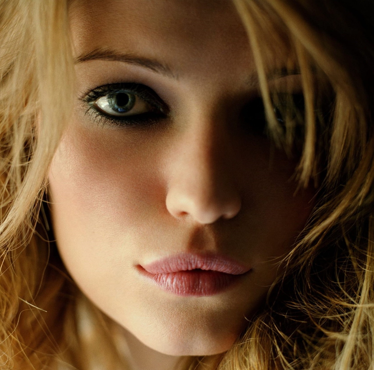 Close-up portrait of woman with blonde hair and blue-green eyes