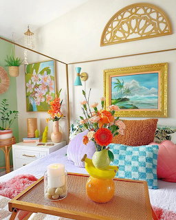 Vibrant living room with tropical flowers, colorful cushions, and beach painting on wall