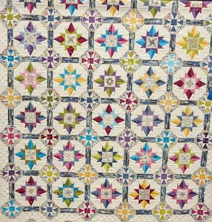 Colorful geometric quilt with star pattern blocks in multiple colors