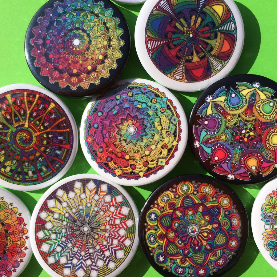 Overhead view of decorative plates with colorful mandala and geometric patterns arranged on green surface
