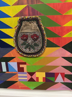 Beaded pouch with red roses on a colorful geometric triangle background painting