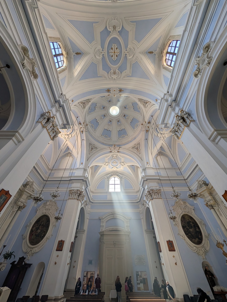 Interior of Chiesa di San Francesco, Monopoli, Italy, with ornate vaulted ceiling and light rays