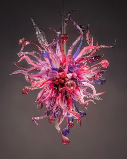 Elaborate blown glass sculpture with pink, purple and blue flowing tendrils radiating outward