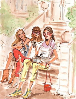 Three women in colorful outfits sitting on stone steps with decorative columns and greenery