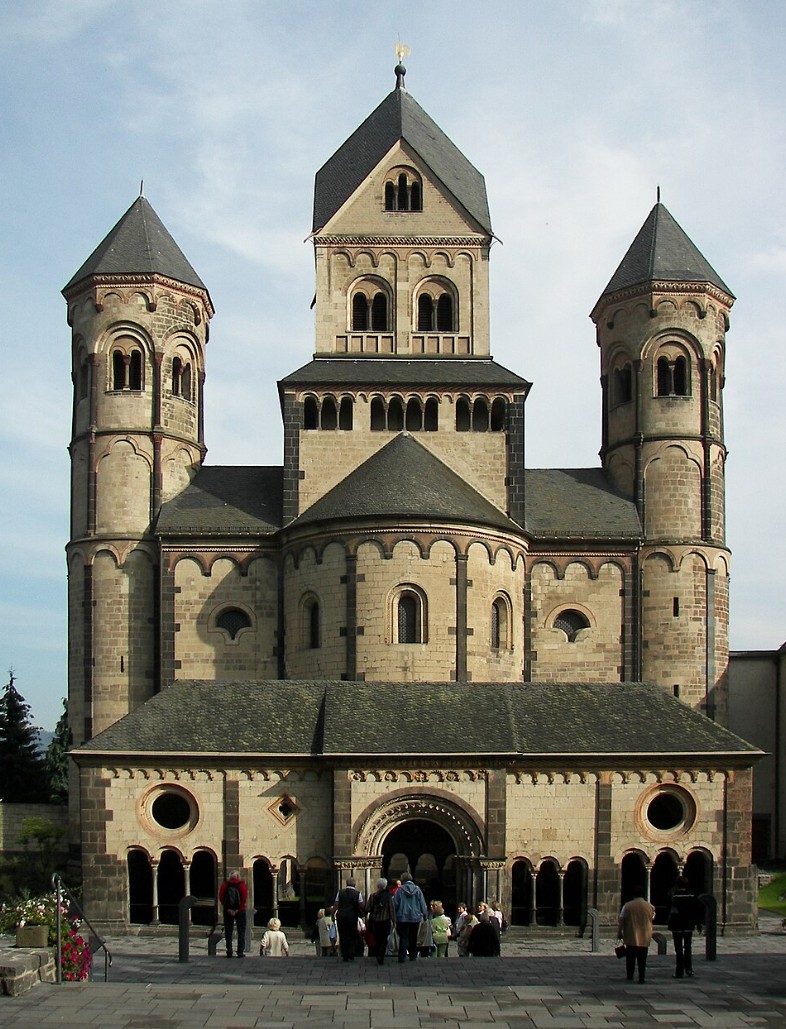 Romanesque Maria Laach Abbey with twin bell towers and central dome against overcast sky