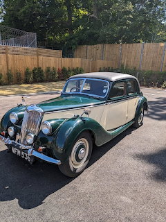 Vintage green and cream classic car parked on a paved lot outdoors