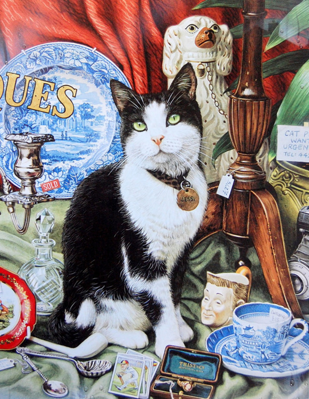 Black and white cat sitting among antique cups, plates, and decorative objects