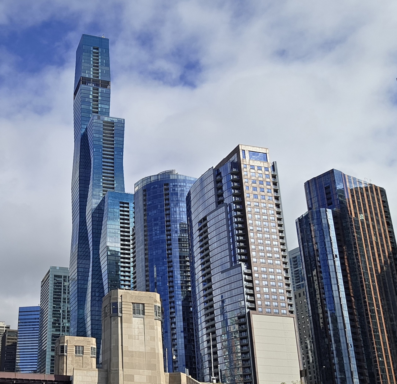 Tall modern skyscrapers in Chicago downtown with blue glass facades under cloudy sky