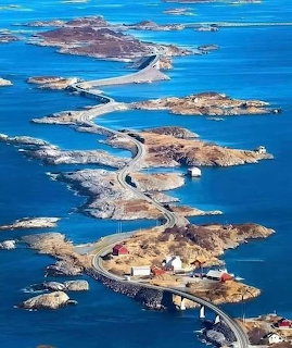 Winding road and bridges connecting rocky islands in a bright blue ocean