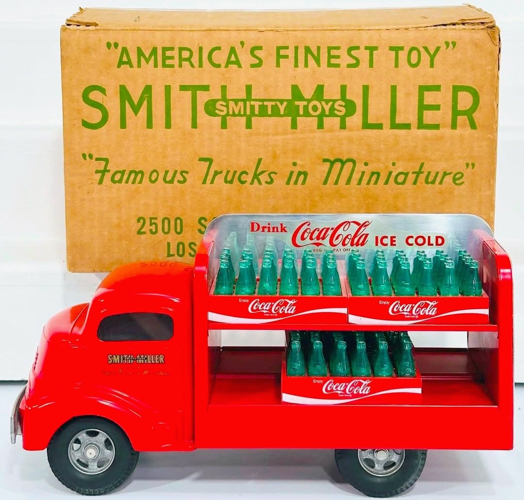 Red vintage Smith Miller toy Coca-Cola delivery truck with miniature bottles in front of original yellow box