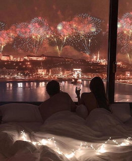 Couple Watching Fireworks from Bedroom