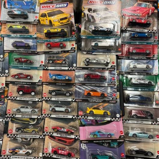Colorful collection of packaged die-cast toy cars arranged in a grid