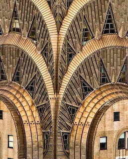 Golden Art Deco building facade with chevron patterns and arched windows