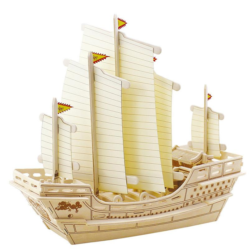 Wooden model sailing ship with cream sails on a white background