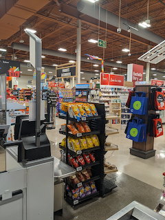 Supermarket checkout area with chip racks and self-service register kiosks