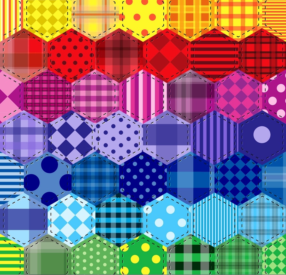 Colorful hexagonal patchwork quilt pattern with various prints in rainbow gradient from red to green