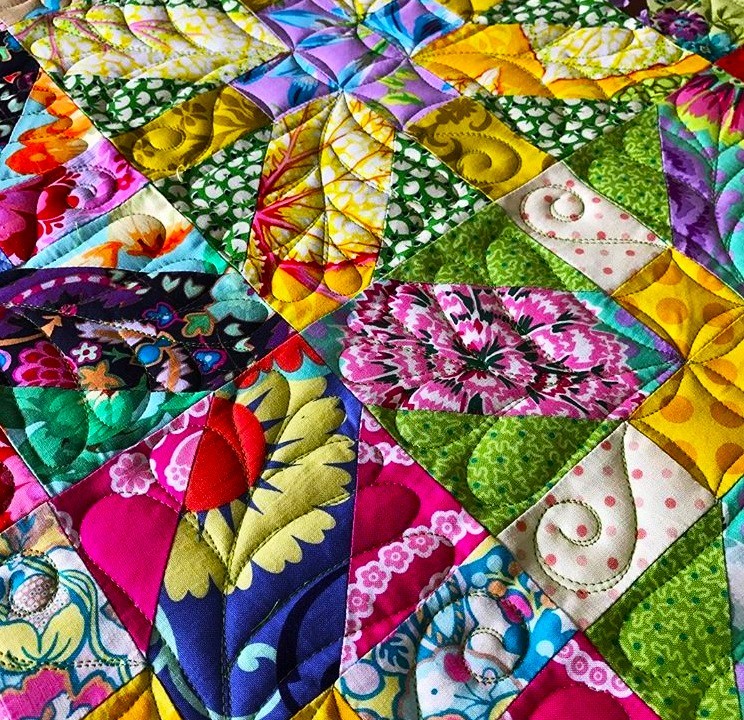 Vibrant patchwork quilt with colorful fabric patches in floral and geometric patterns