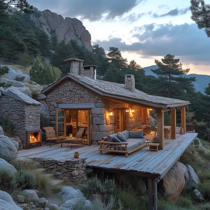 Rustic stone cabin with lit windows on a rocky mountain slope at dusk