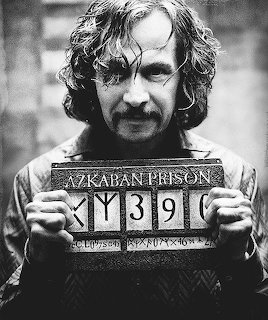 Black and white mugshot of Sirius Black holding Azkaban Prison prisoner number board