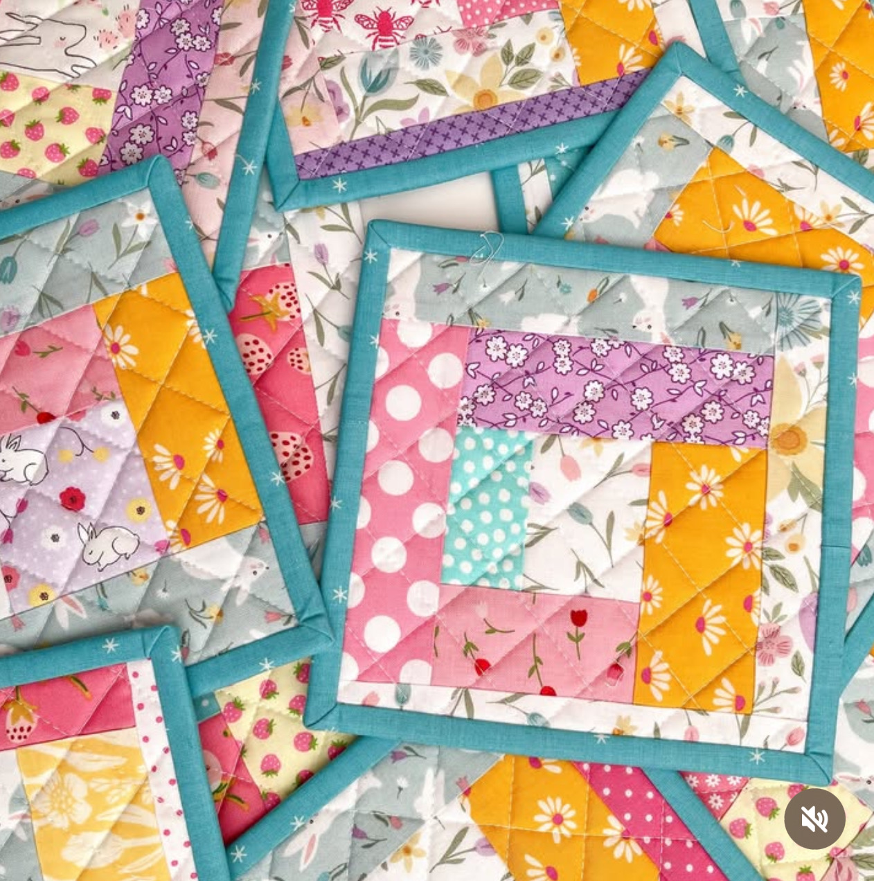 Close-up of colorful patchwork quilt blocks with floral, polka dot, and geometric fabric patterns