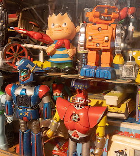Shelf display of colorful vintage toy robots and retro figurines indoors