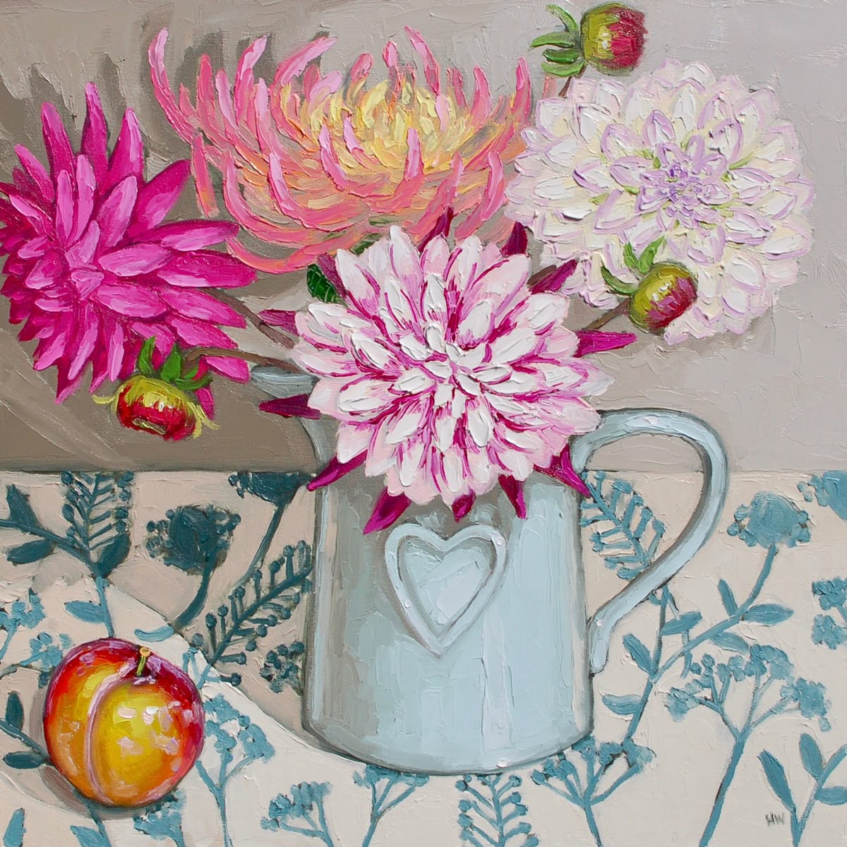 Pink and white dahlias in blue ceramic pitcher on floral tablecloth with fruit
