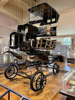 Ford Model T car suspended and displayed in exploded view showing all separated components in museum