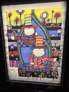Colorful folk art painting of two figures in a boat with abstract flowers and geometric patterns