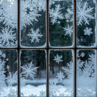 Intricate frost and snowflake patterns on window panes with winter landscape behind