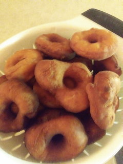 White bowl piled high with golden brown homemade fried doughnuts or beignets