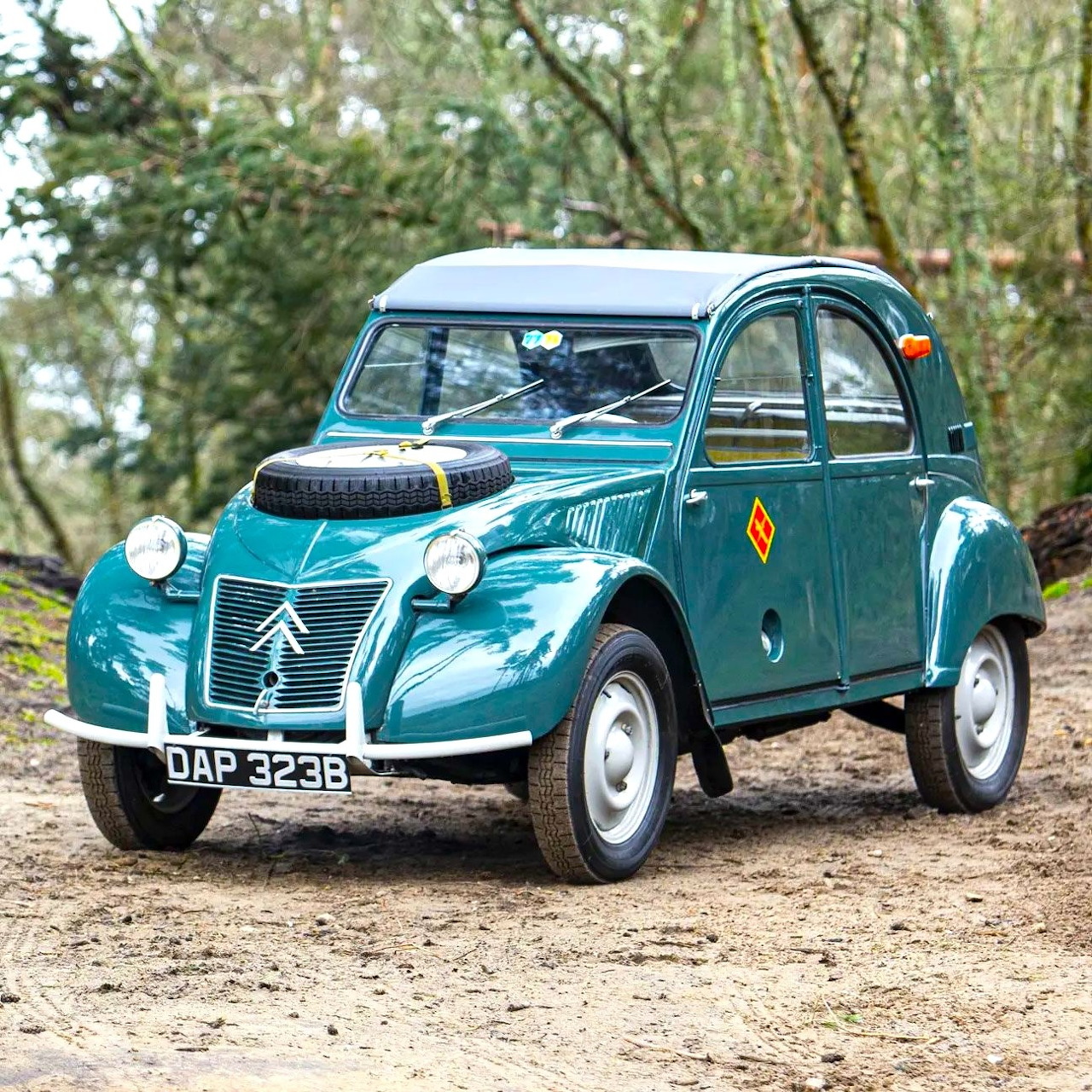 Turquoise 1964 Citroën 2CV 4x4 Sahara classic car on gravel with trees behind