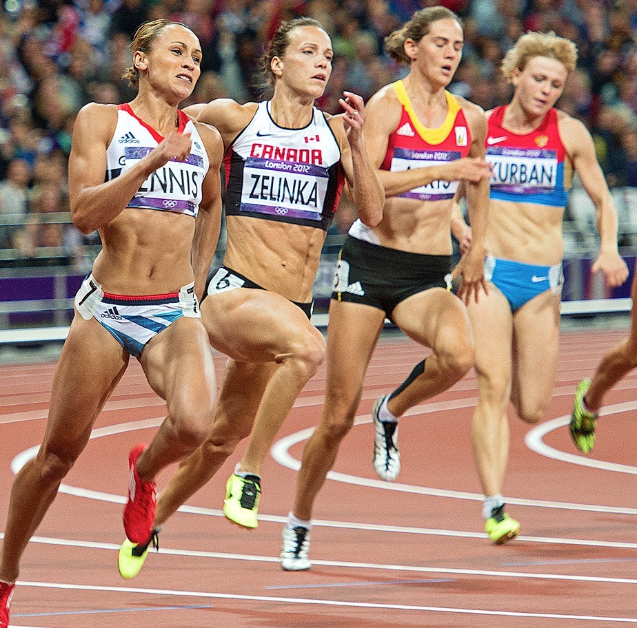 Female athletes running in a track race on a stadium track