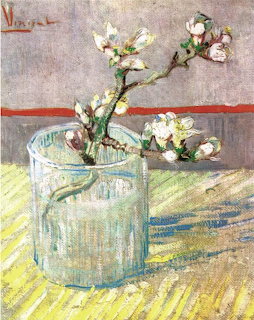 Van Gogh painting of white almond blossoms in a glass vase on a table