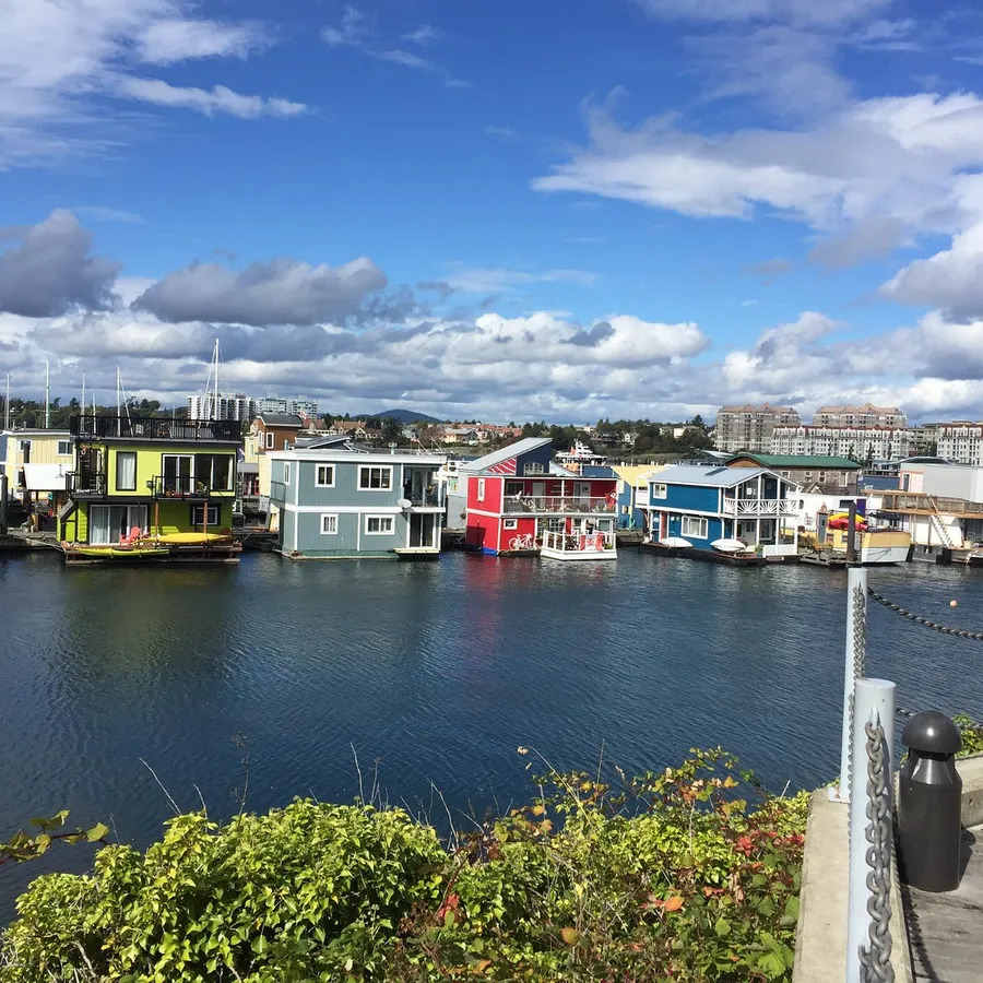 Colorful floating houses in harbor with blue sky and clouds