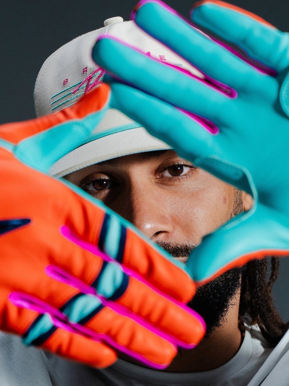 Close-up of Fernando Tatis Jr with bright blue and orange gloves framing his face