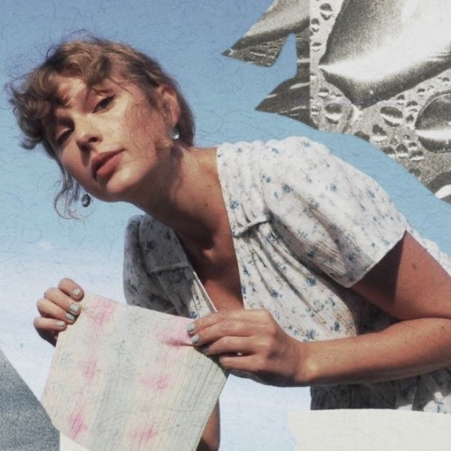 Taylor Swift posing against a blue background while holding a pastel sheet of paper