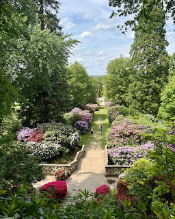 Elevated view of Hever Castle gardens with colorful flowering shrubs along a stone pathway