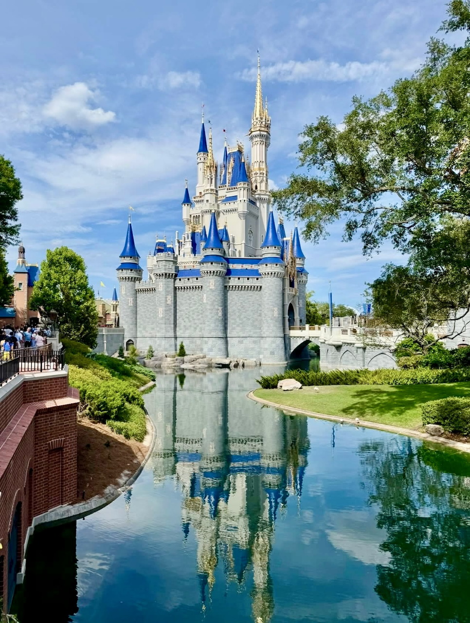 Cinderella Castle with blue turrets reflected in water at Disney World's Magic Kingdom