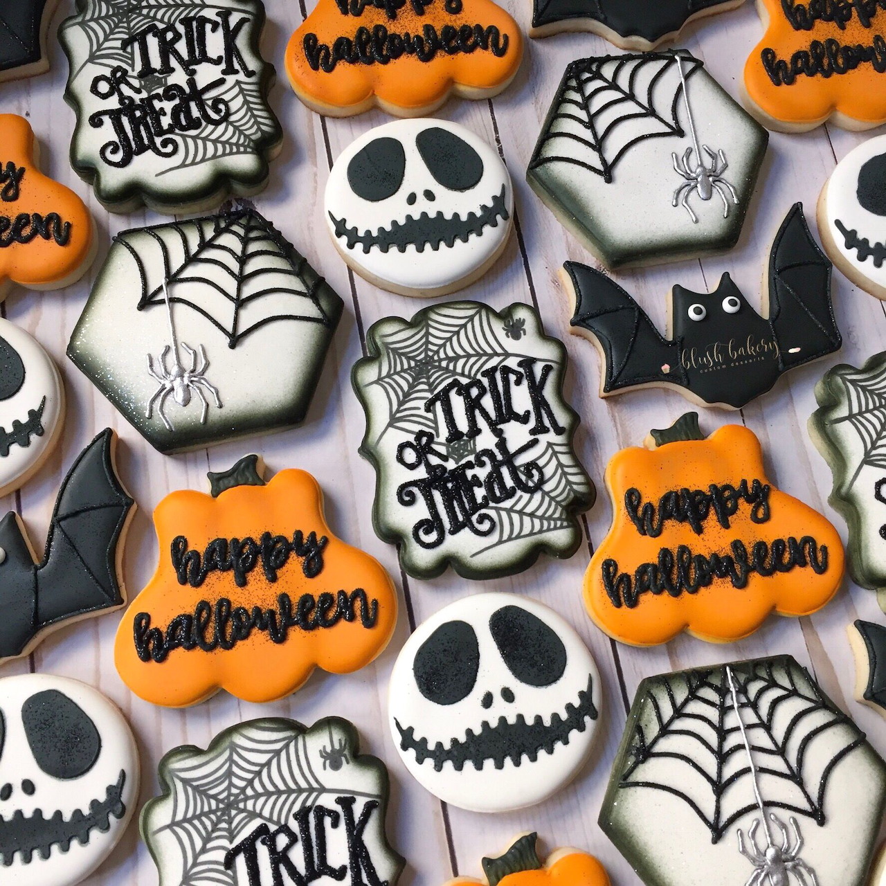 Halloween iced cookies with pumpkins, skulls, spiderwebs, bats, and trick-or-treat designs