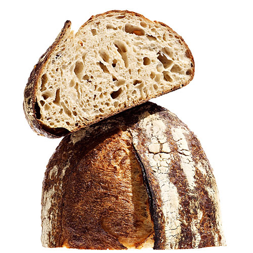 Sliced artisan sourdough bread showing open crumb texture and dark crust