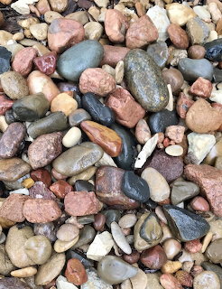 Collection of colorful smooth pebbles and stones in various sizes and natural colors