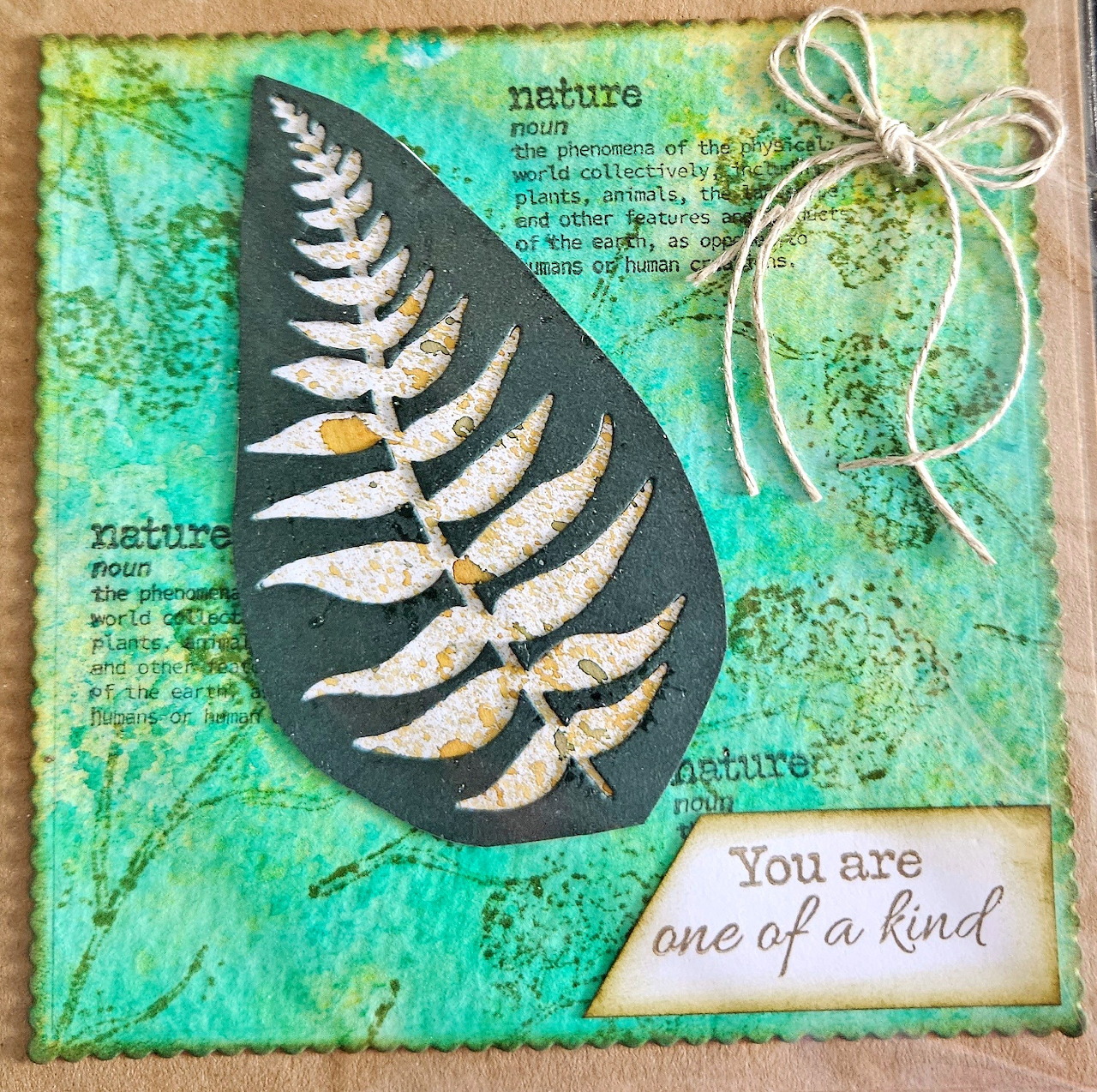 Handmade card with turquoise background, fern leaf teardrop design, ribbon bow, and 'one of a kind' message
