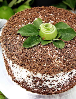 Round cake with chocolate shavings, topped with a green apple rose and leaves