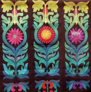 Three colorful ornamental floral columns with flower medallions on a dark background